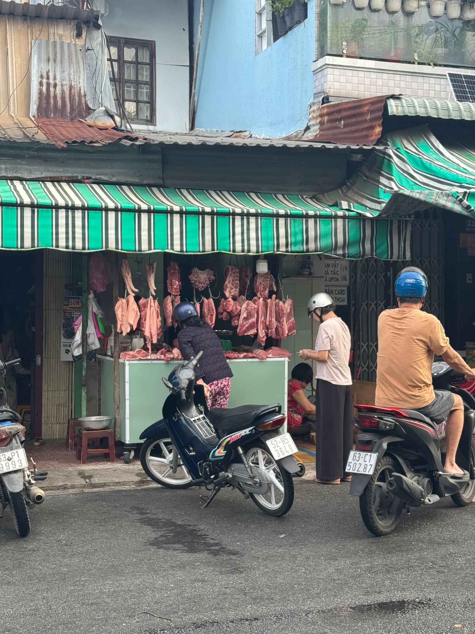 Mặt tiền tiệm thịt heo Bé Sáu với mái hiên sọc xanh lá trắng, số 530
